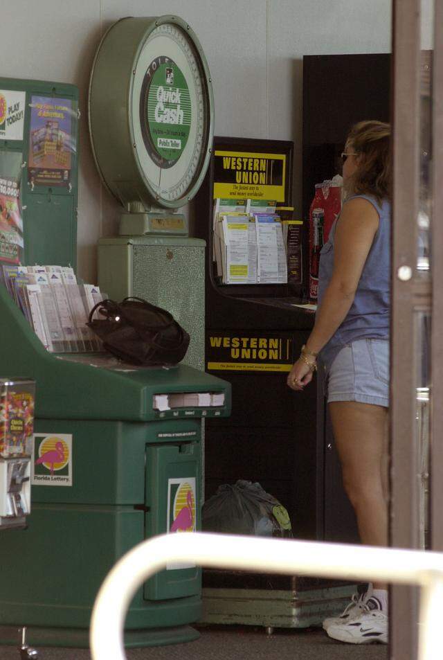 In this file photo from June 22, 2001, a customer weighed a small bag of clothing at a Publix at 13890 SW 56th St. She planned to send the clothes to Cuba with someone who was traveling there. It weighed five pounds. Airlines were cracking down on weight restrictions. Publix considered removing the scales from Miami-area stores at the time as heavy baggage was damaging them.